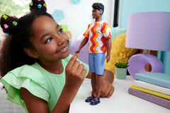 Barbie Fashionistas Ken-Puppe Nr. 220 mit Hörgeräten und breiter Körperform in einem abnehmbaren Shirt mit orangefarbenem Muster, Shorts und Plateau-Sandalen, HRH23