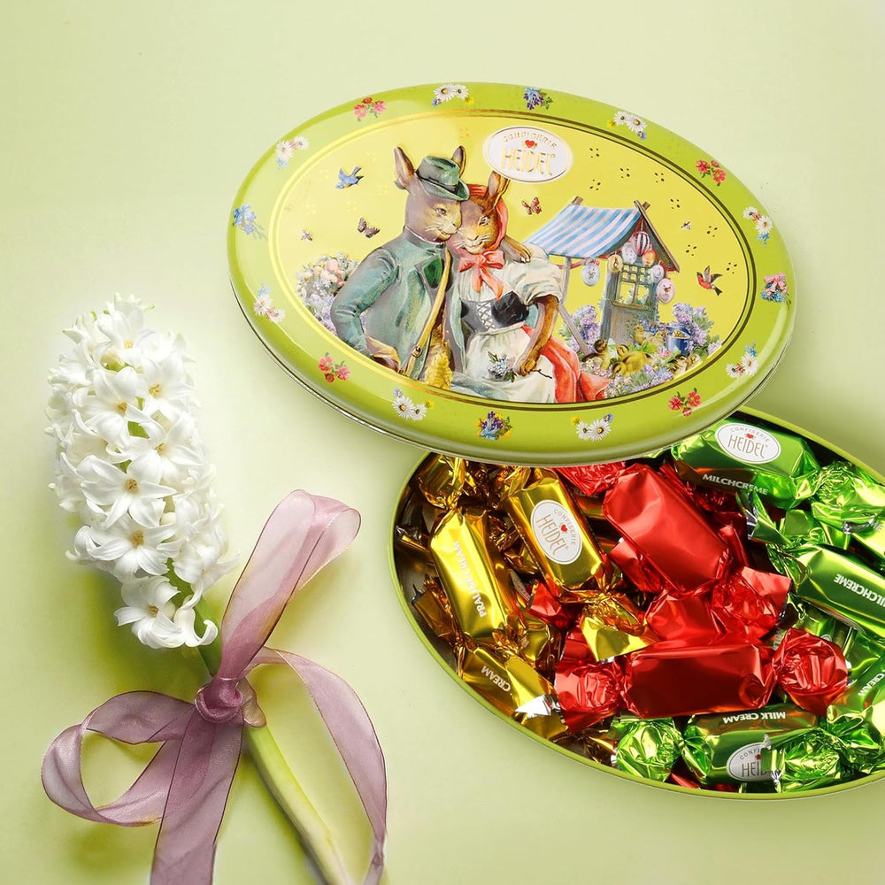 Cutie cadou Heidel cu felicitări de Paște 183g, praline premium din ciocolată cu lapte cu cutie metalică decorativă, ideală ca și cadou de Paște