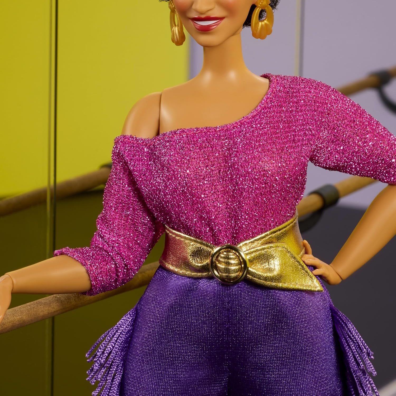 Păpușa Barbie Signature, Colecția Debbie Allen Tribute, cu bluză cu umeri goi, curea aurie și pantaloni mov cu franjuri și jambiere, JBJ24